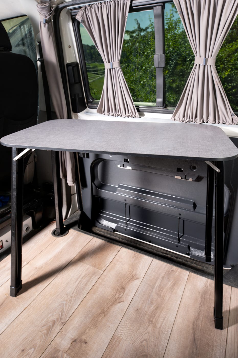 HideMyTable: der ausgeklappte Campingtisch an der offenen Schiebetür eines VW Busses